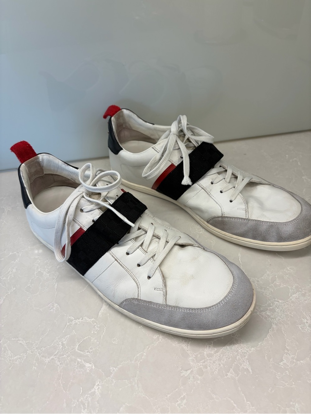 Louis Vuitton Men's White Leather Casual Sneakers with Gray and Red Accents.